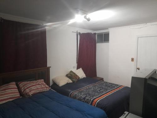 维纳德马Hostal batuco的一间设有两张床和电视的房间