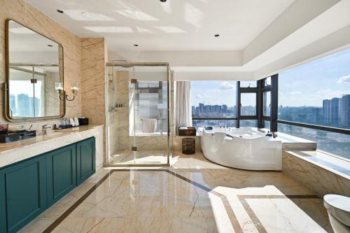 广州广州番禺总统大酒店的带浴缸的浴室和大窗户