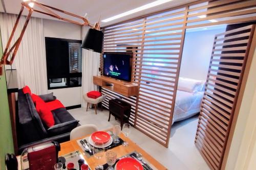 圣保罗Hotel MRC PINHEIROS- The Best Excellence Duplex Studio Pinheiros - Red Velvet Deluxe Edition - First Class - By LuXXoR的客厅设有大窗户和电视