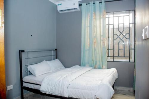 达累斯萨拉姆Swahili Homes- Ada Estate的一间卧室设有一张大床和窗户