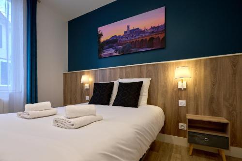 讷韦尔Le Faidherbe style Appart' Hôtel - WIFI gratuit - Parking Gratuit Calme et Lumineux的卧室配有一张白色大床,墙上挂有绘画作品