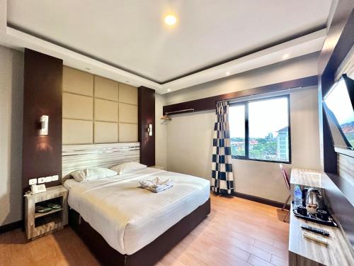 坤甸My Home Hotel Pontianak的一间卧室设有一张大床和一个大窗户