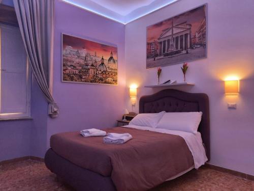 罗马Royal Vatican的一间卧室配有一张床,上面有两条毛巾