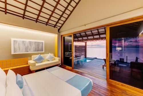 Felidhoo Cinnamon Velifushi Maldives的一间卧室配有一张床,享有海景