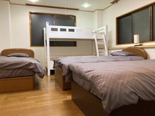 东京Sky Tree INN Ⅱ（晴樹宿Ⅱ）的一间卧室配有两张床和一张双层床。