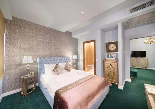 布加勒斯特Phoenicia Comfort Hotel的一间卧室配有一张大床和电视
