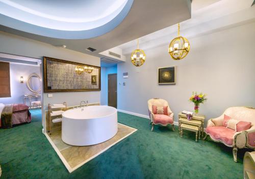 布加勒斯特Phoenicia Comfort Hotel的带浴缸、椅子和床的客房