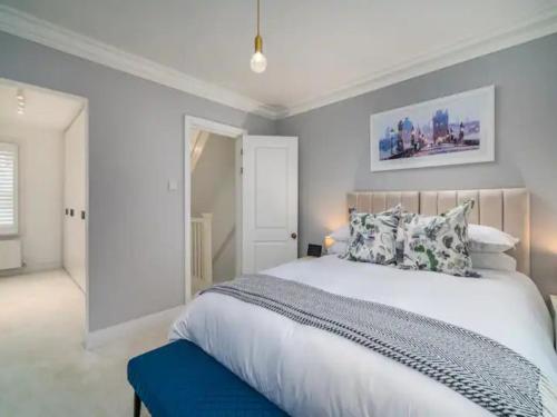 圣奥尔本斯Pass the Keys Luxury 2 Bedroom Townhouse in Central St Albans的一间卧室配有一张白色大床和蓝色长凳