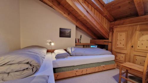 席尔瓦普拉纳Chesa Bellaval, Haus la Vuolp 2-Zimmer-Dachwohung的卧室设有2张床和木制天花板。