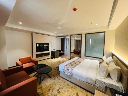 艾哈迈达巴德Hotel Mivaante的酒店客房配有床、沙发和电视。