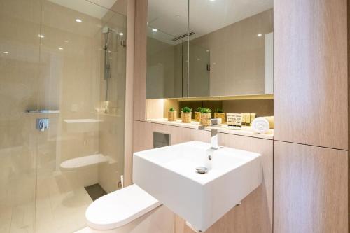 悉尼Contemporary 2-Bed Apartment Minutes to City的浴室配有白色水槽和卫生间。