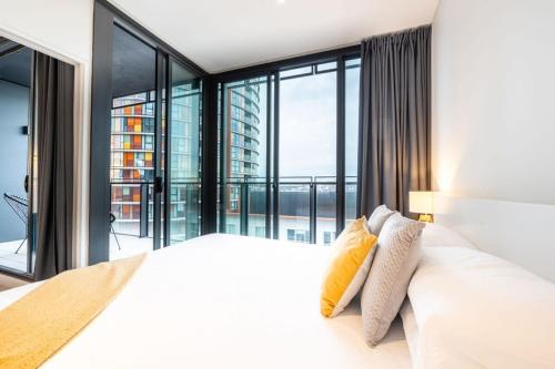 悉尼Contemporary 2-Bed Apartment Minutes to City的卧室配有白色的床和大窗户