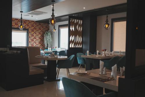 NamsaiHotel Namlau的用餐室设有桌椅和窗户。