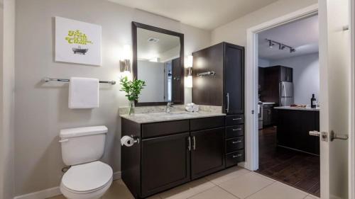 达拉斯Bold CozySuites with pool, gym, roof #2的浴室设有卫生间和带镜子的盥洗盆