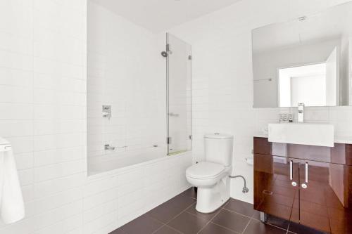 悉尼Spacious 2-Bed with Two Balconies with City Views的浴室配有卫生间、浴缸和水槽。
