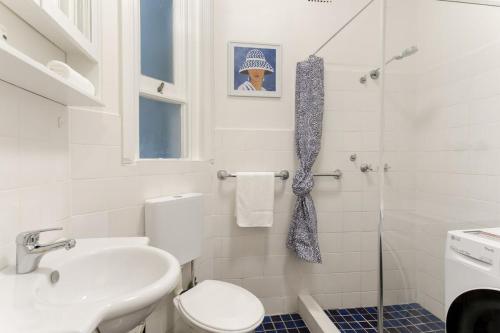 悉尼Art Deco Apartment Meters Away From The Beach的浴室配有卫生间、盥洗盆和淋浴。
