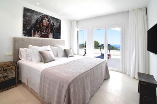 圣何塞德萨塔莱阿Teodoro - Ibiza的卧室配有一张大床,墙上挂有绘画作品
