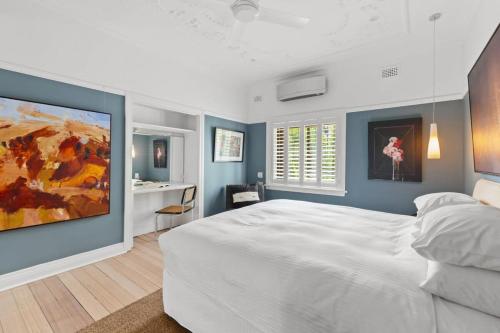 悉尼Superb 2-Bed Apartment Facing Rose Bay Marina的卧室配有白色大床和蓝色的墙壁