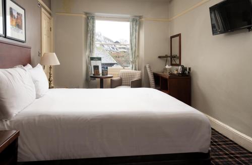 安布尔塞德The Ambleside Inn - The Inn Collection Group的酒店客房设有一张白色大床和一个窗户。