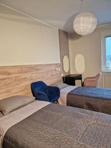 哥德堡Premium Avkoppling Tre Rum av Perfektion的酒店客房,设有两张床和一张蓝色椅子