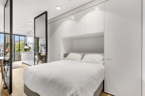 墨尔本Contemporary 1-Bed in the Heart of St Kilda的卧室配有一张大白床和大镜子
