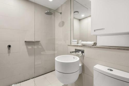 墨尔本Contemporary 1-Bed in the Heart of St Kilda的白色的浴室设有卫生间和玻璃淋浴间。