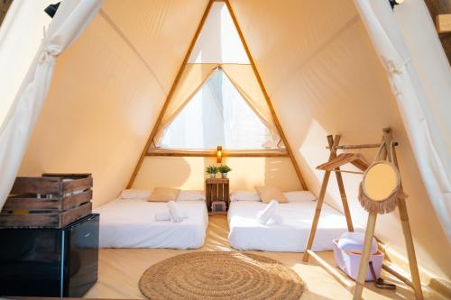 阿尔科斯-德拉弗龙特拉Kampaoh Lago de Arcos的帐篷内带两张床的房间