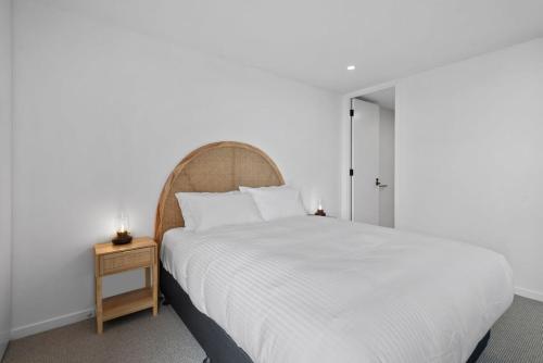 墨尔本Bespoke 2-Bed Beachfront Apartment的卧室配有一张白色的大床和床头柜。