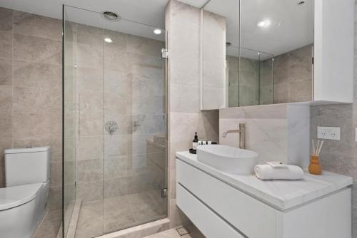 墨尔本Bespoke 2-Bed Beachfront Apartment的浴室配有卫生间、盥洗盆和淋浴。
