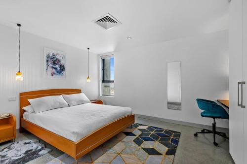 墨尔本Vibrant 2-Bed Apartment Near St Kilda Beach的一间卧室配有一张床、一张桌子和一把椅子