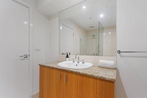 墨尔本Unbeatable 2-Bed Apartment In City Centre的一间带水槽和镜子的浴室