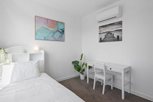 伯伍德Stylish and Convenient Two Bedroom Apartment的白色卧室配有书桌和床