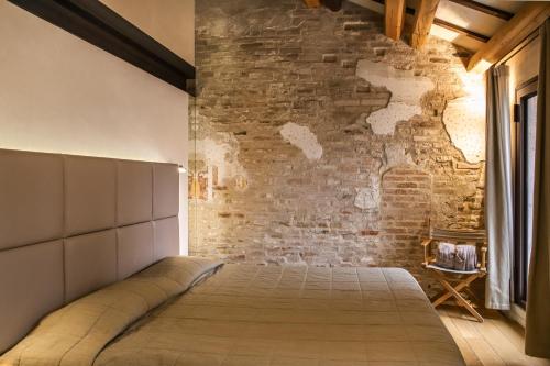 特雷维索罗坎达庞特丹住宿加早餐旅馆的砖墙房间的一个床位