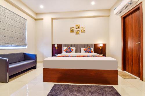 斋浦尔FabHotel Pravaasam Residency的一间卧室配有一张床和一张沙发