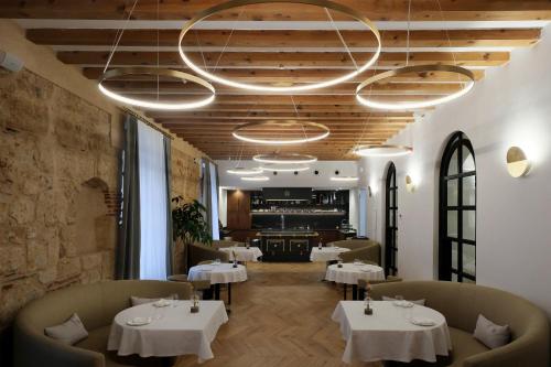 萨拉曼卡Eunice Hotel Gastronómico的一间带桌椅和吊灯的餐厅