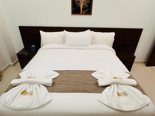 尼兹瓦السمو ALSMOU للشقق الفندقية的一间卧室配有一张带白色毛巾的床