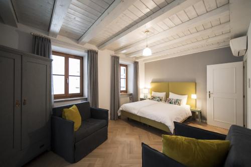 博尔扎诺Bogen bistro & apartments的一间卧室配有一张床和一张沙发