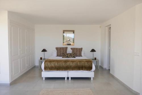 卡拉隆加Villa Dream - Santa Eulalia的白色卧室配有一张大床和两盏灯。