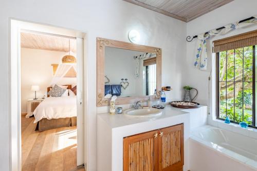 普利登堡湾Tidal Retreat的一间带水槽和镜子的浴室以及一张床