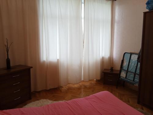 巴库Квартира в престижном районе Баку的卧室配有白色窗帘、梳妆台和镜子