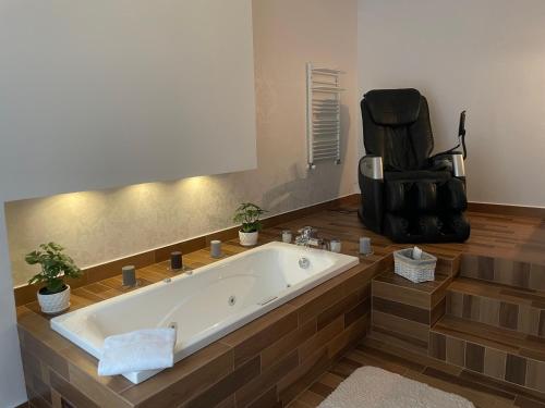 德罗希琴Hotel Drohicki的带浴缸的浴室和椅子