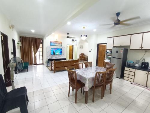 马西Rinting Corner Islamic Homestay, Pasir Gudang的厨房以及带桌椅的起居室。
