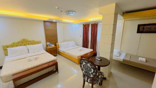达沃市安克拉酒店的酒店客房设有两张床和一张桌子。