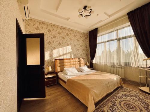 奎兹洛达Dostyk的一间卧室设有一张床和一个大窗户