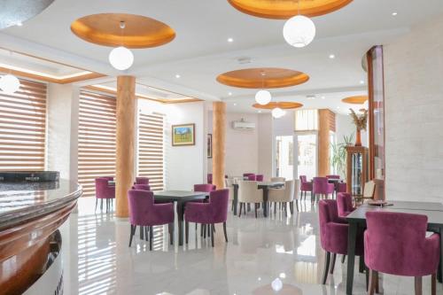 乌尔齐尼Imperial Hotel的一间用餐室,配有紫色的椅子和桌子