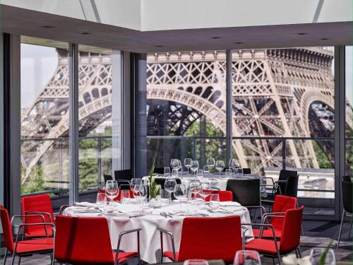 巴黎铂尔曼度假巴黎埃菲尔铁塔酒店的一间带桌子和艾菲尔铁塔的用餐室