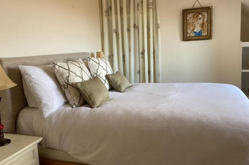ClegganDrop Anchor House, Spacious 3 bedroom apartment, fabulous sea views的卧室内的一张带枕头的白色床