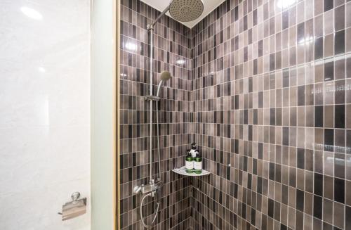 丽水市Wate Hotel的浴室设有棕色瓷砖和淋浴。