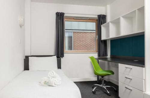 卢顿Wenlock Court的小房间设有一张床和一把绿色椅子