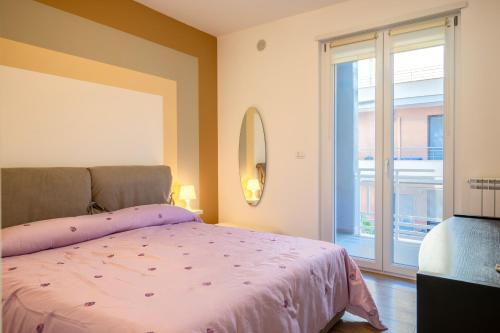 布林迪西Casadamare Salento的卧室设有粉红色的床和大窗户
